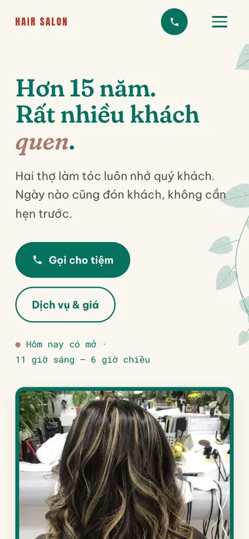 The same salon site in Vietnamese on a phone.